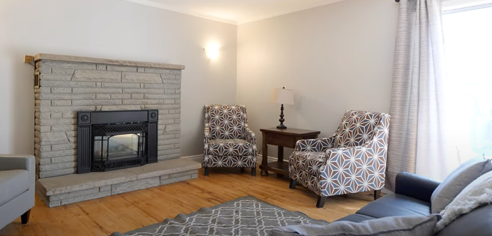 The Light House living room with a couch, two chairs, and a fireplace.